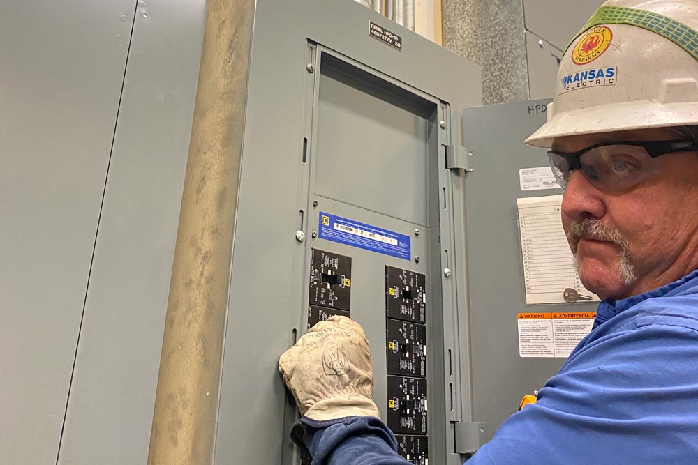 Kansas Electric employee working on a fuse box